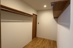 ウォークスルークローゼット。棚とハンガーポール付き。収納スペースとしては自由度もあり大変便利です。